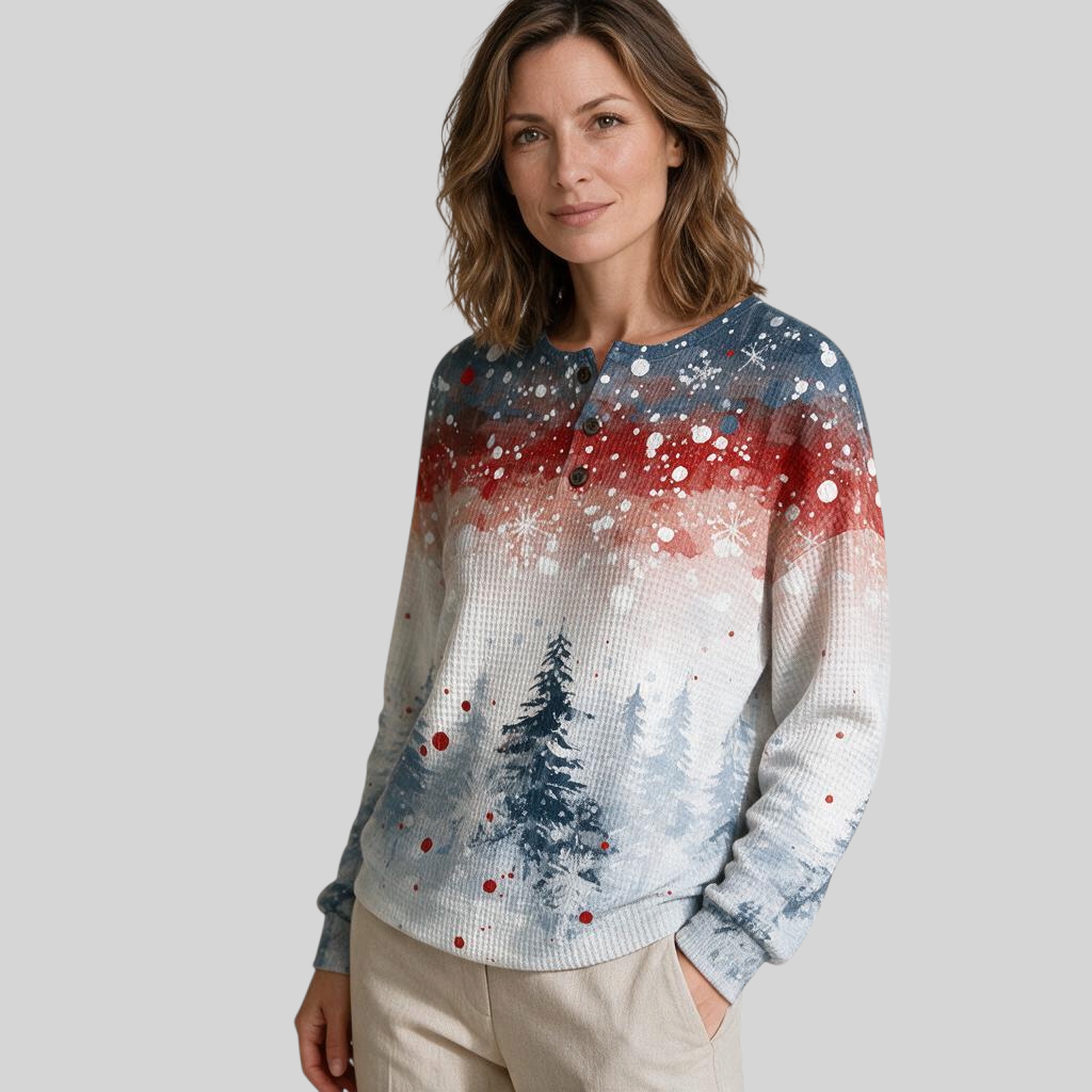 Mulher vestindo blusa de moletom A minha loja 2 com estampa natalina de pinheiros, neve e detalhes em vermelho e azul